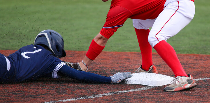 Third baseman tagging out runner who is head first sliding - Powered by Adobe