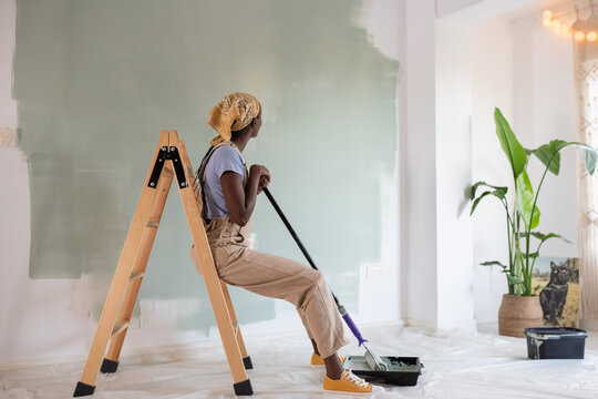 Black painter admiring work results