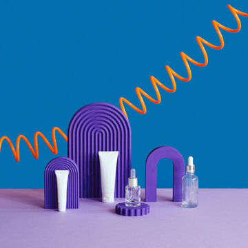 Set of cosmetics serum bottles on blue violet background