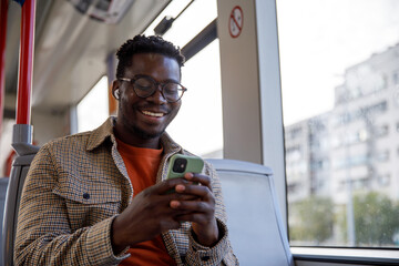 Man listening music using mobile phone and earphones in tram
