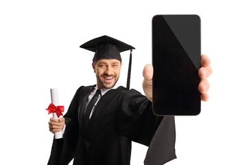 Man in a graduation gown holding a diploma and showing a smartphone