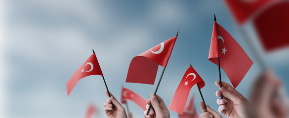 A group of people holding small flags of the Turkey in their hands - obrazy, fototapety, plakaty