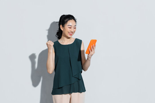 Asian beautiful woman raise arm up and holding smartphone