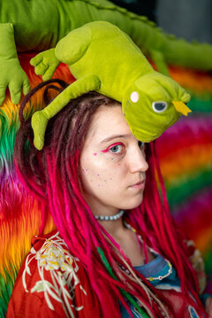 young woman with colored dreadlocks and pink makeup