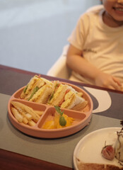 kids meal set, club sandwich with eggs fruits and vegetables, carrot tomato and cord, on food grade plate for kid, children or toddler, top view