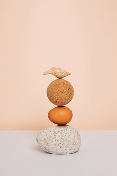 Stone, egg, ball and shell stacked still life