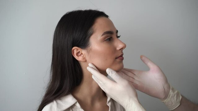 4k video Rhinoplasty is reshaping nose surgery for change appearance of the nose and improve breathing. ENT doctor is touching nose and consulting girl patient before septoplasty surgery.