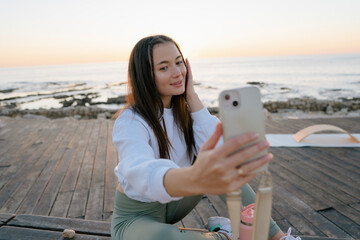 Young woman having rest and making selfie after exercising