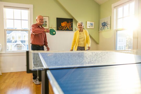 Retired Senior Citizen lifestyle couple playing ping pong game  home 