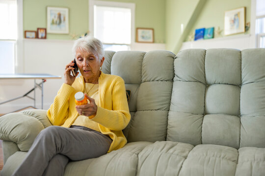 Senior woman with prescription pill drug medication on mobile phone 