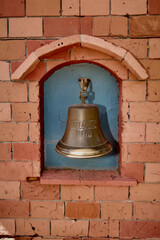 Obraz premium Bronze bell on a brick wall with the inscription Titanic 1912