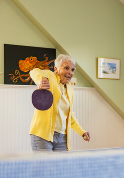 Active Senior Citizen hobby  woman playing ping pong game at home 