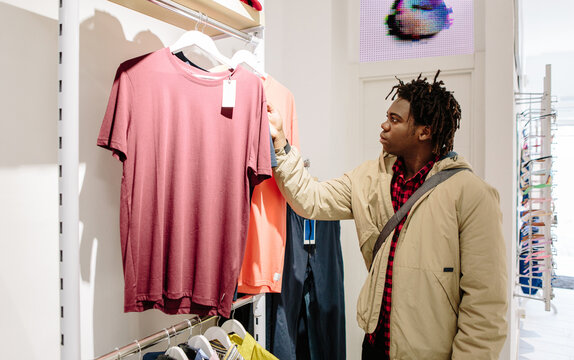 Young guy looking at clothes in a shop