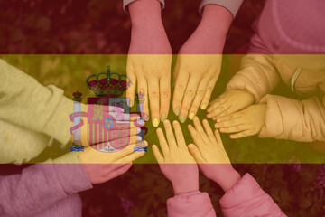 Hands of kids on background of Spain flag. Spanish patriotism and unity concept.