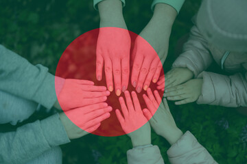 Hands of kids on background of Bangladesh flag. Bangladeshi patriotism and unity concept.