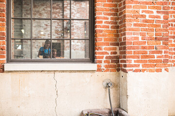 Reflection of family in an historic window of a brick building