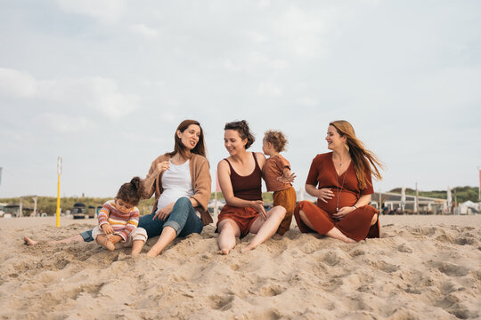 Group of mothers sitting on the beach