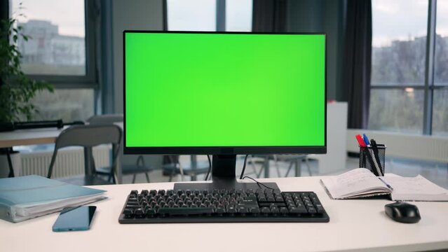Personal Computer With Green Mock Up Screen On Desktop In Office Interior