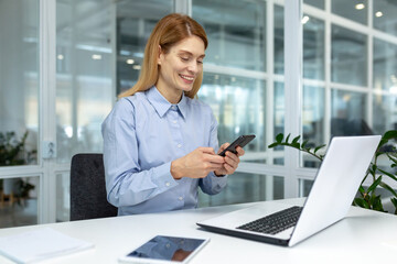Successful mature businesswoman boss using phone at workplace inside modern bright office, office...