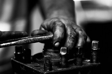 Closeup of human hand working with metallic tools