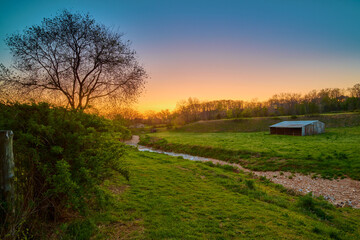 Sunset over a farm with old barn near Bentonville Arkansas. - obrazy, fototapety, plakaty