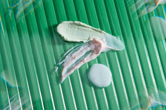 Samples of cosmetic cream on color background