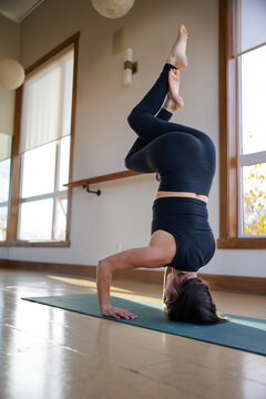 Woman in eagle headstand yoga pose.