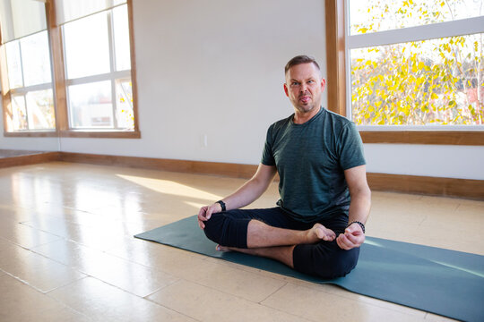 Happy yoga portrait in studio with mat.