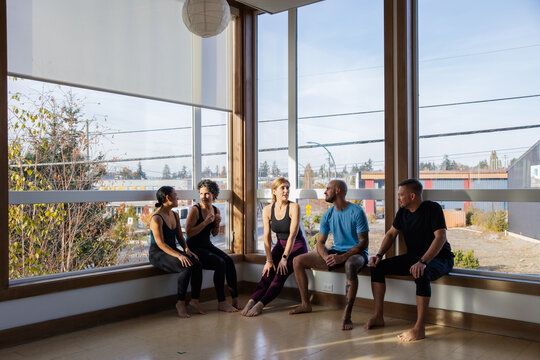Friends chatting in workoutspace near the window.