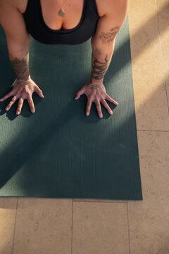 Woman practicing yoga upward dog in bright studio.