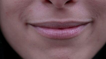 Fototapeta premium Macro closeup of a woman mouth smiling. Extreme close up of adult girl lips and teeth with happy expression