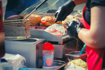 Burger cooking outdoors. Fast food restaurant with french fries and burgers.