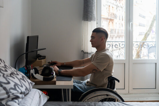Young Adult Wheelchair User Using A Desktop Computer