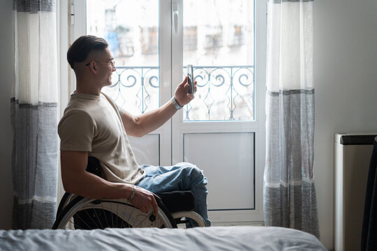 Man With Paraplegia Uses A Smartphone At Home.