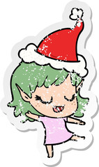 happy distressed sticker cartoon of a elf girl wearing santa hat