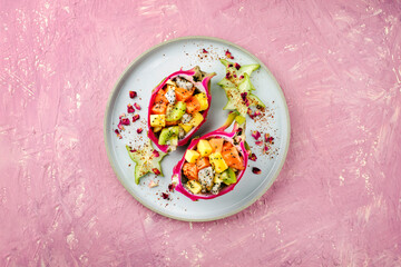 Traditional Valentines Day fruit salad with exotic fruit pieces served in dragon fruit bowls and...