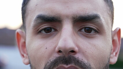 Obraz premium One Middle Eastern man portrait eyes looking at camera with serious expression. Arab male person close up eyes