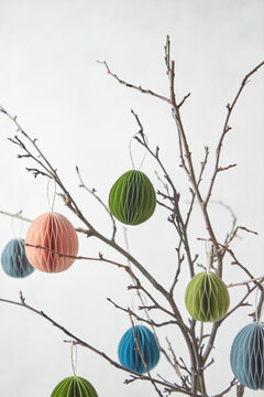 Handicraft paper Easter eggs hung on twigs.