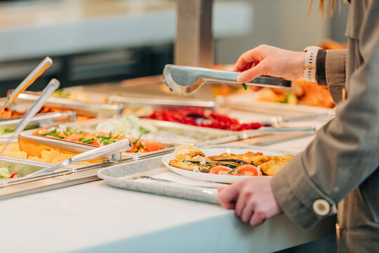 woman puts food on her plate at the buffet, closeup view