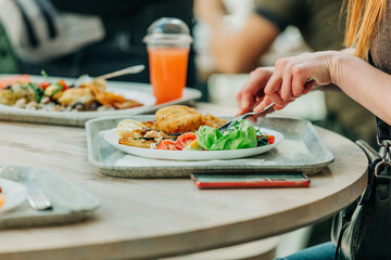 girl eating salade and jelly at the table in the cafe