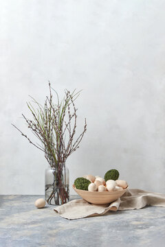 Fresh twigs with moss and wooden Easter eggs.