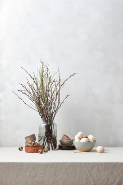 Willow twigs on table with wooden Easter eggs.