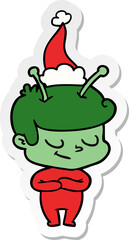 friendly sticker cartoon of a spaceman wearing santa hat