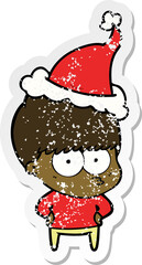 nervous distressed sticker cartoon of a boy wearing santa hat