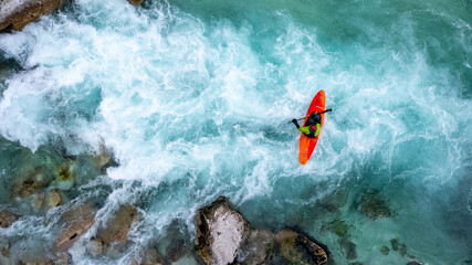 Drone shot of whitewater kayaker dealing with crystal clear rapids of Soca river in Slovenia  - obrazy, fototapety, plakaty