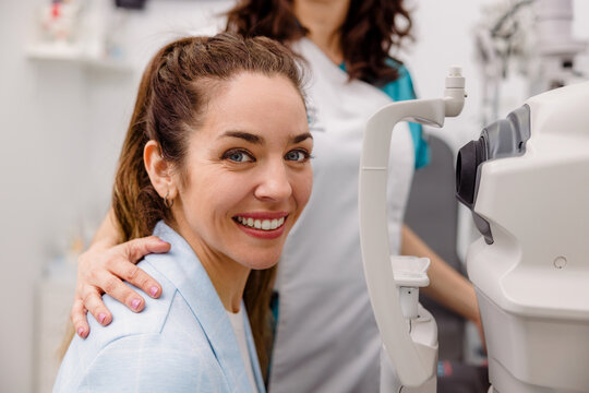 Smiling patient sitting near autorefractor