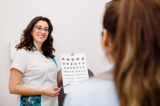 Oculist checking patients eyesight with eye chart