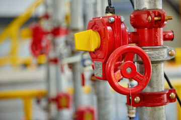 Red fire water valve on the piping system of the industrial firefighting system in the technological complex. Components of automatic fire extinguishing system.   