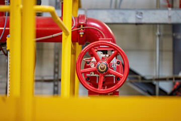 Red fire water valve on the piping system of the industrial firefighting system in the technological complex. Components of automatic fire extinguishing system.   