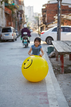 Asian girl having fun in the old city block with her mood balloons